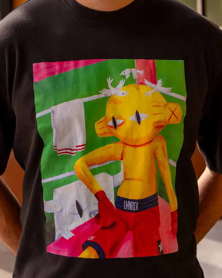 Defeated Tee by Naji Al-Ali LMNBCK — black cotton t-shirt with bold LMNBCK illustrated graphic artwork