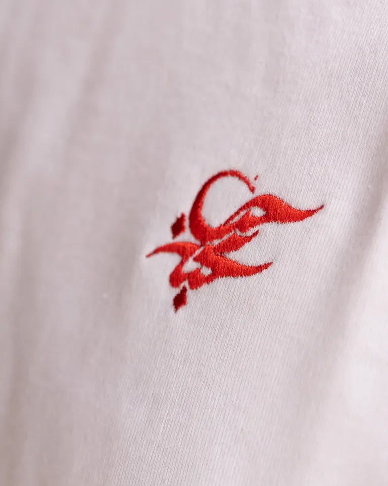 Eternal Tee by Wissam Shawkat — white cotton t-shirt with black Arabic calligraphy in circular composition with red accents