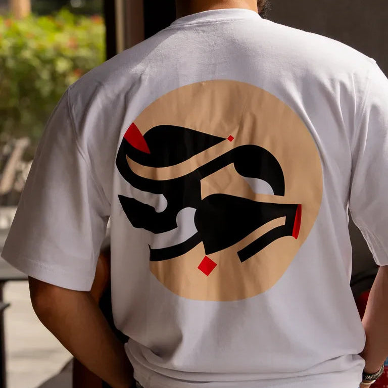 Eternal Tee by Wissam Shawkat — white cotton t-shirt with black Arabic calligraphy in circular composition with red accents