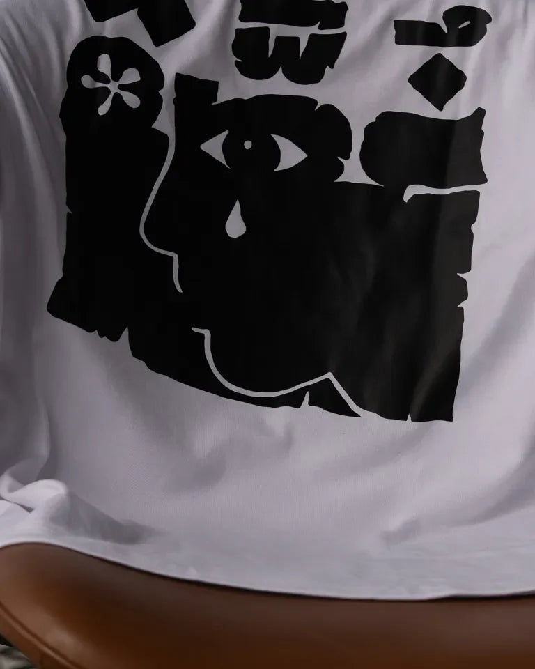 Ghosseh Tee by Ibrahim Zaki — white cotton t-shirt with embroidered Arabic calligraphy expressing layered emotion