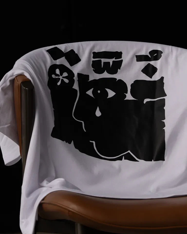 Ghosseh Tee by Ibrahim Zaki — white cotton t-shirt with embroidered Arabic calligraphy expressing layered emotion