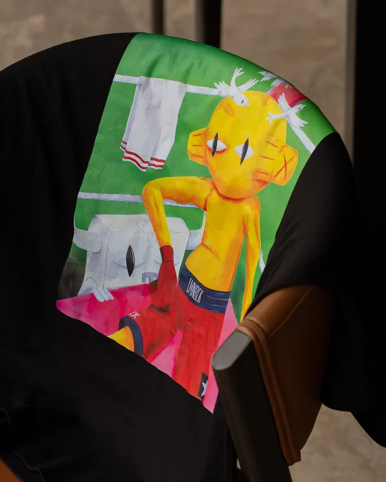 Defeated Tee by Naji Al-Ali LMNBCK — black cotton t-shirt with bold LMNBCK illustrated graphic artwork