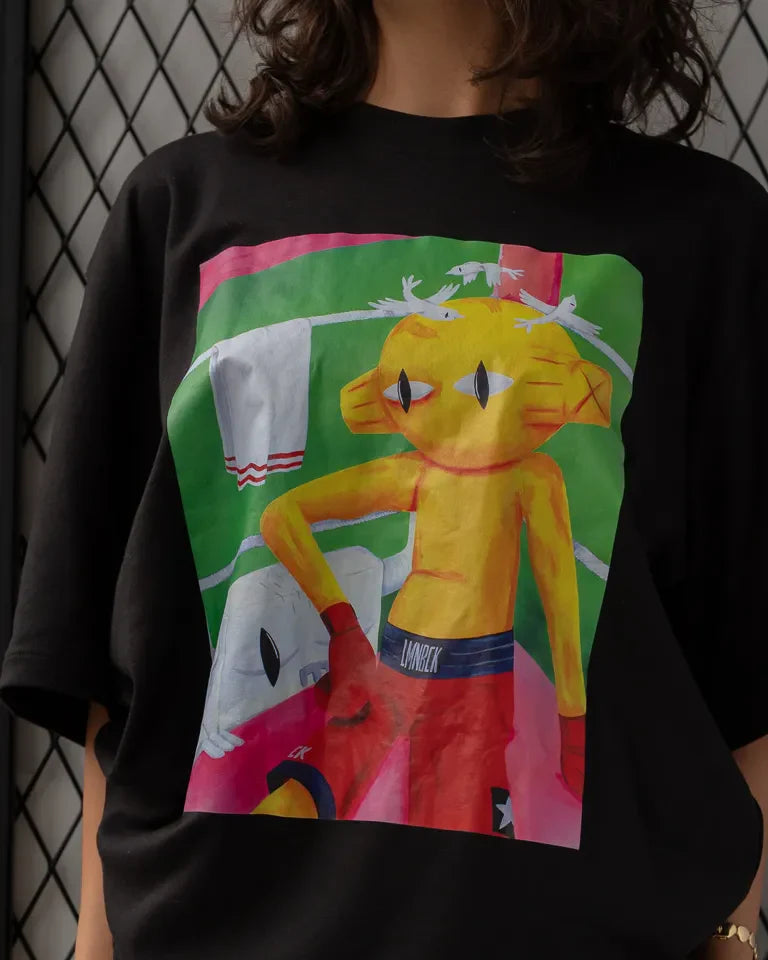 Defeated Tee by Naji Al-Ali LMNBCK — black cotton t-shirt with bold LMNBCK illustrated graphic artwork
