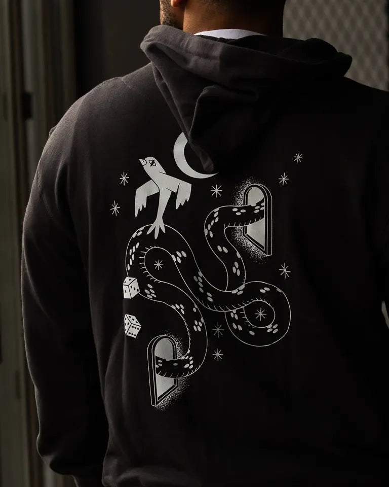 Snake Eyes Hoodie by Naji Al-Ali LMNBCK — black premium cotton hoodie with monochrome LMNBCK graphic illustration