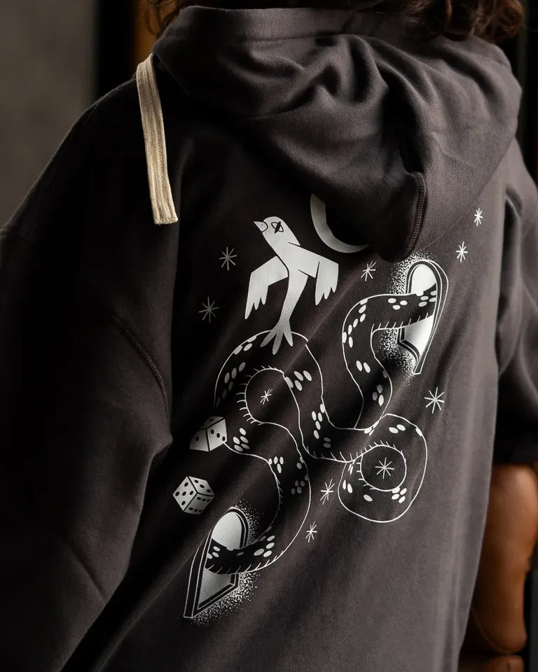 Snake Eyes Hoodie by Naji Al-Ali LMNBCK — black premium cotton hoodie with monochrome LMNBCK graphic illustration