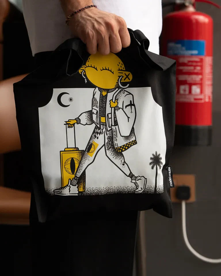 Laymona Travel Tote Bag by Naji Al-Ali LMNBCK — black canvas tote with bold illustrated LMNBCK character design