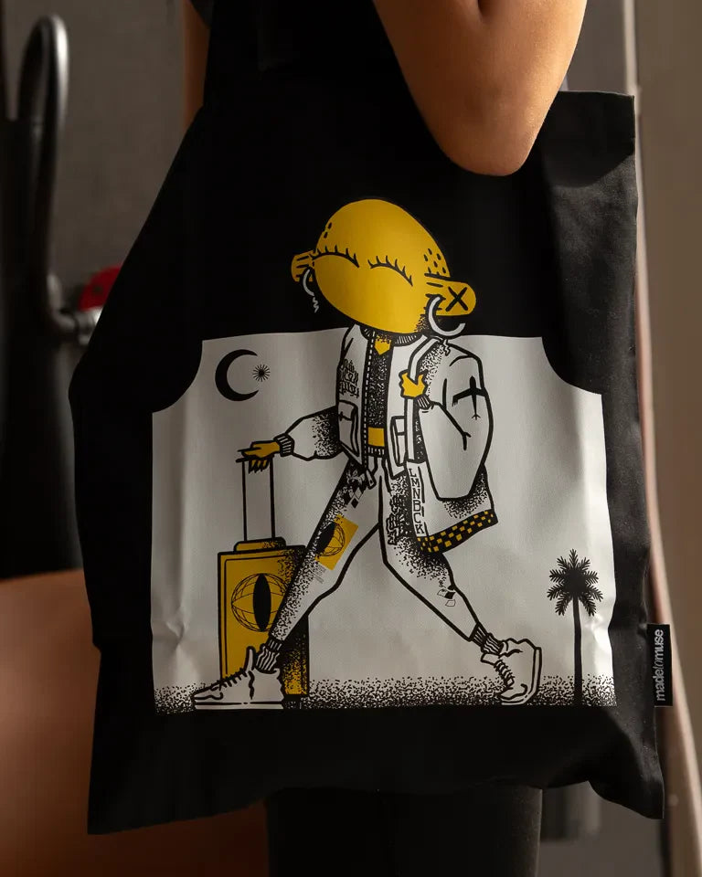 Laymona Travel Tote Bag by Naji Al-Ali LMNBCK — black canvas tote with bold illustrated LMNBCK character design