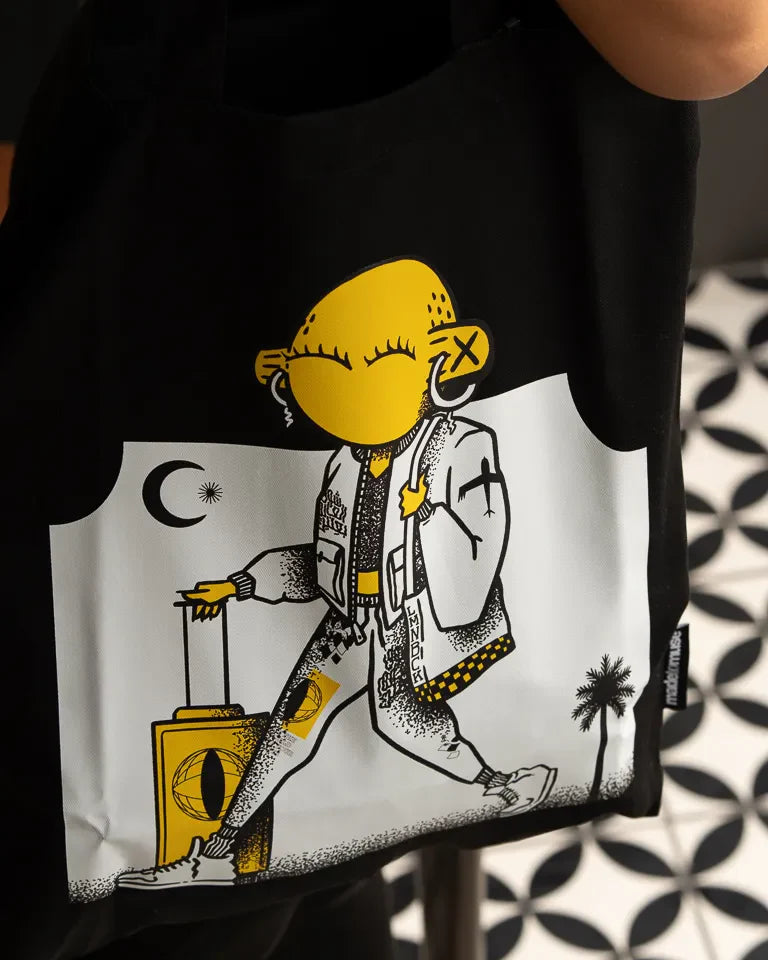 Laymona Travel Tote Bag by Naji Al-Ali LMNBCK — black canvas tote with bold illustrated LMNBCK character design