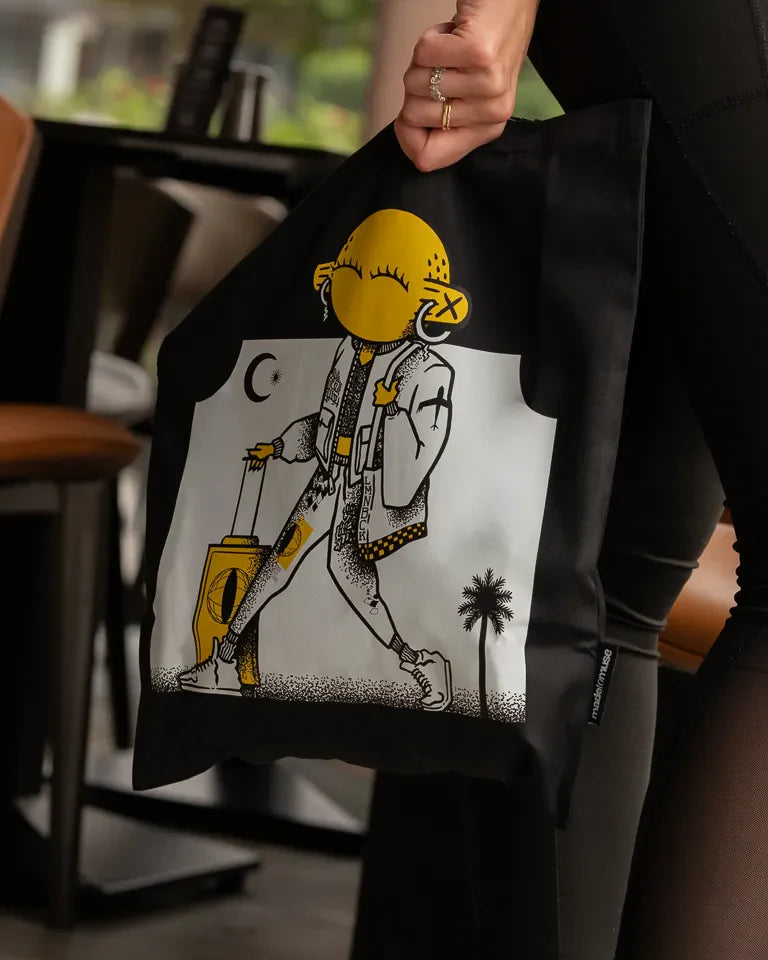 Laymona Travel Tote Bag by Naji Al-Ali LMNBCK — black canvas tote with bold illustrated LMNBCK character design