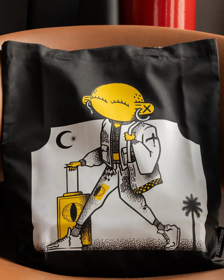 Laymona Travel Tote Bag by Naji Al-Ali LMNBCK — black canvas tote with bold illustrated LMNBCK character design