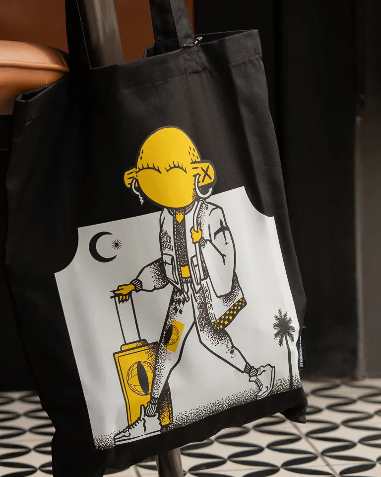 Laymona Travel Tote Bag by Naji Al-Ali LMNBCK — black canvas tote with bold illustrated LMNBCK character design