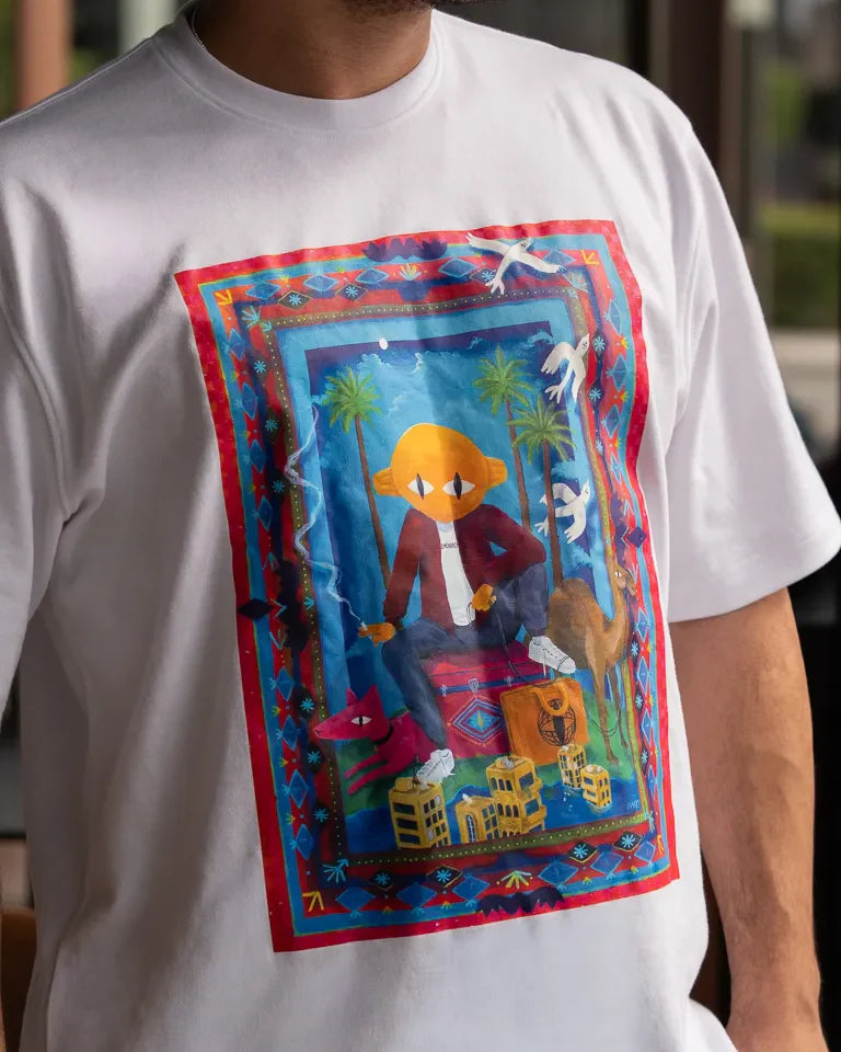 Traveler Tee by Naji Al-Ali LMNBCK — white cotton t-shirt with vibrant illustrated LMNBCK character artwork