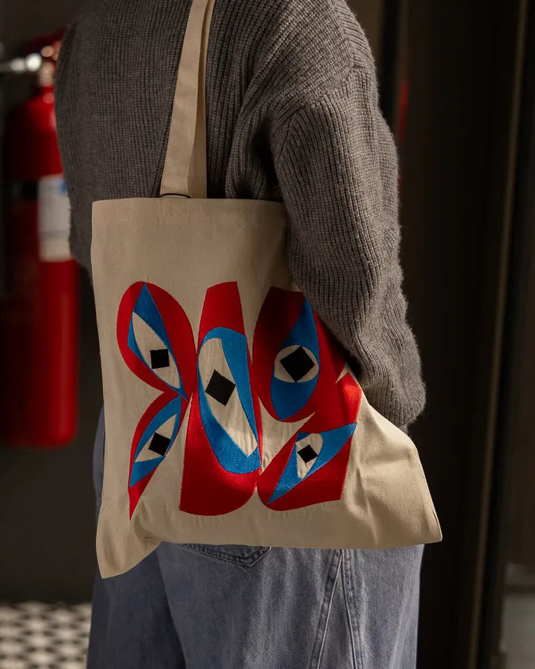 Inside Outside Tote Bag by Wissam Shawkat — natural canvas tote with embroidered bold red and blue Arabic calligraphy