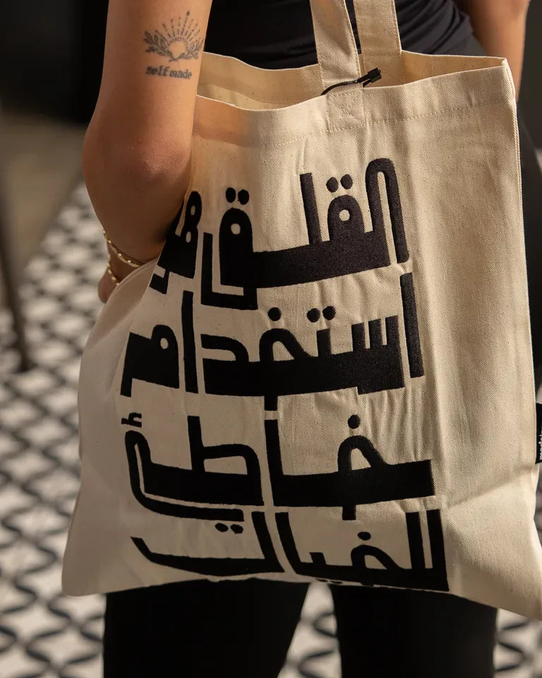Imagination Misused Tote Bag by Ibrahim Zaki — natural canvas tote with bold embroidered Arabic typography