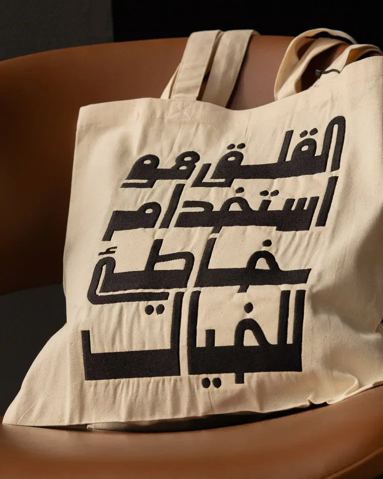 Imagination Misused Tote Bag by Ibrahim Zaki — natural canvas tote with bold embroidered Arabic typography