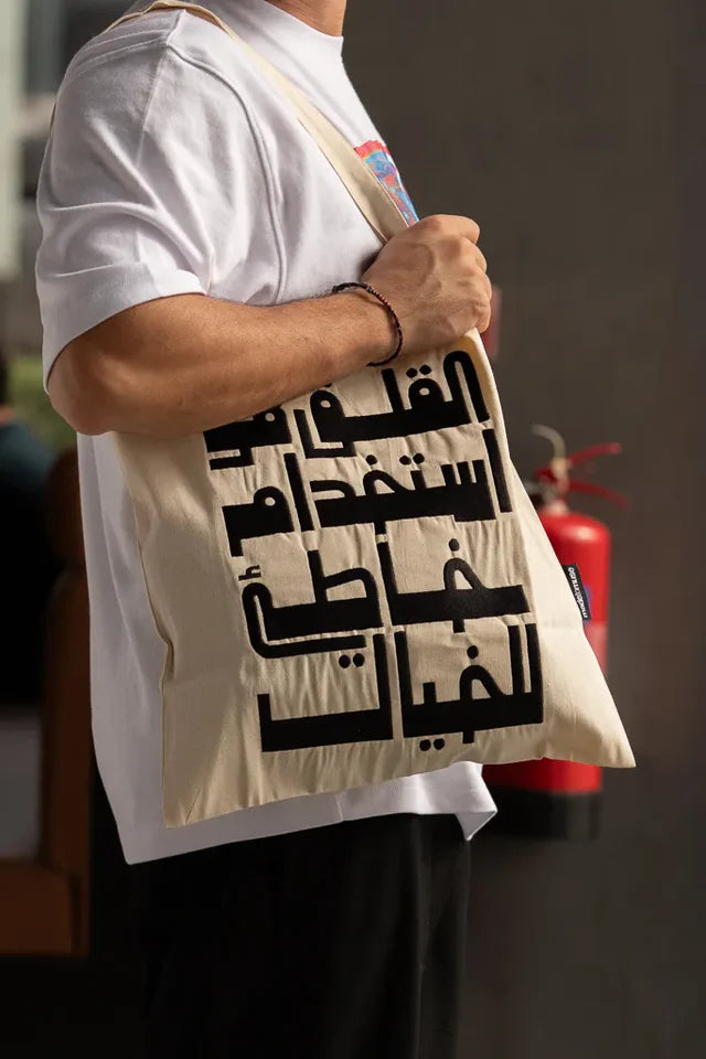 Imagination Misused Tote Bag by Ibrahim Zaki — natural canvas tote with bold embroidered Arabic typography