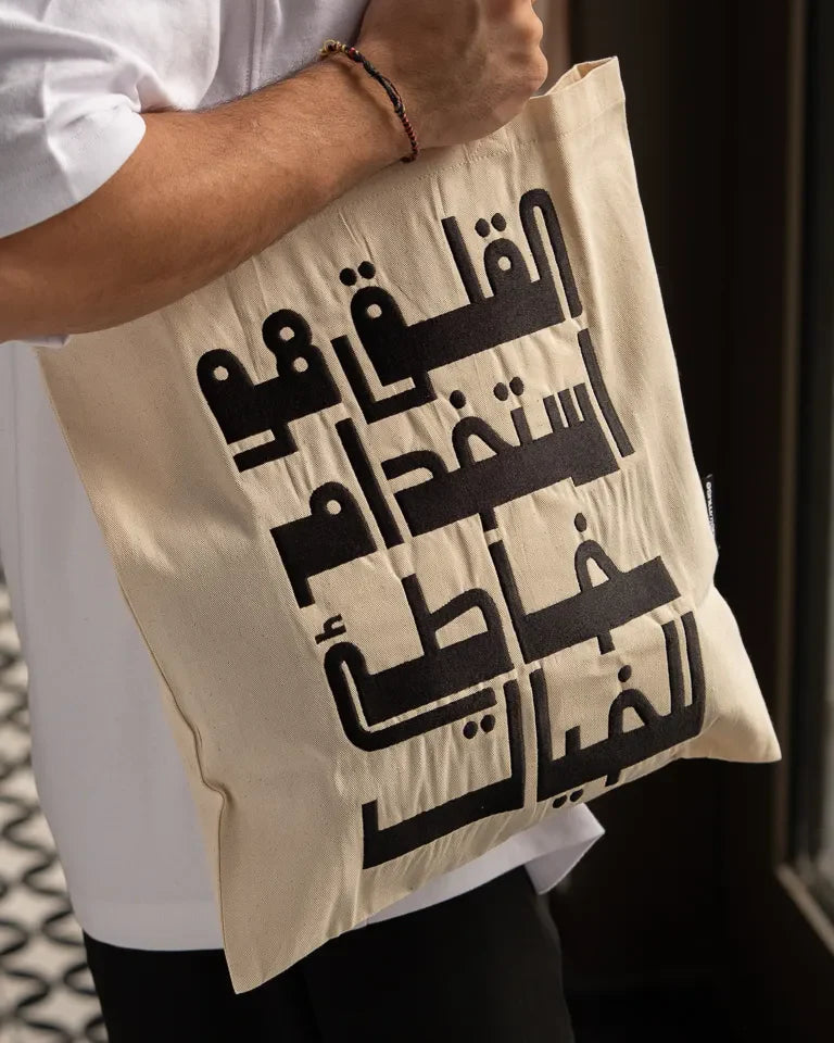 Imagination Misused Tote Bag by Ibrahim Zaki — natural canvas tote with bold embroidered Arabic typography