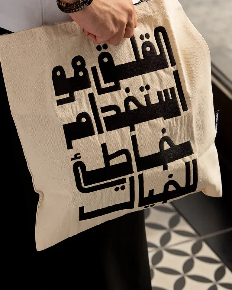 Imagination Misused Tote Bag by Ibrahim Zaki — natural canvas tote with bold embroidered Arabic typography