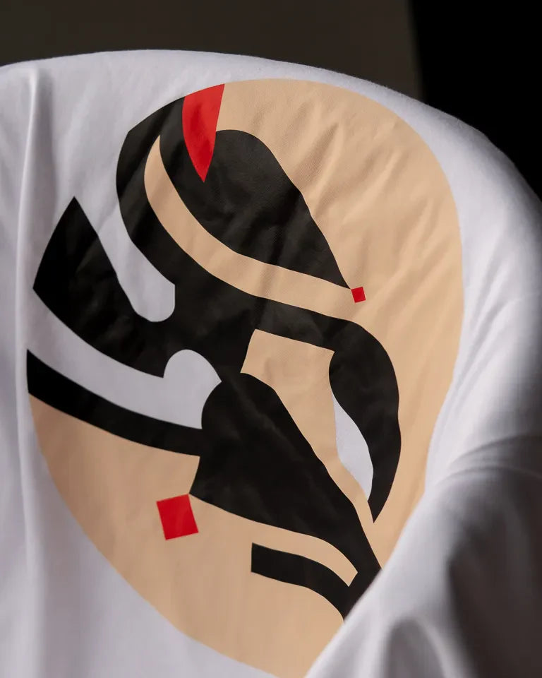 Eternal Tee by Wissam Shawkat — white cotton t-shirt with black Arabic calligraphy in circular composition with red accents