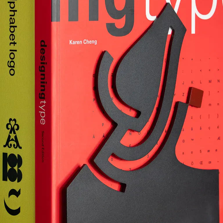 Eternal Bookends by Wissam Shawkat — precision-cut steel bookends with Arabic calligraphy in matte black and red