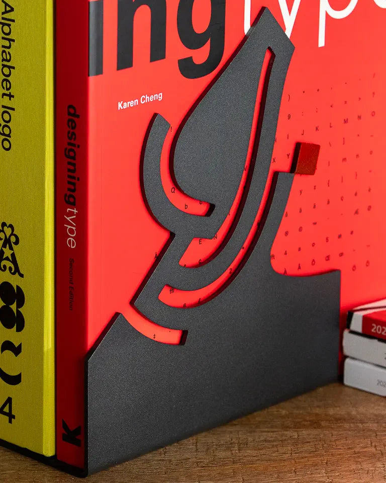 Eternal Bookends by Wissam Shawkat — precision-cut steel bookends with Arabic calligraphy in matte black and red