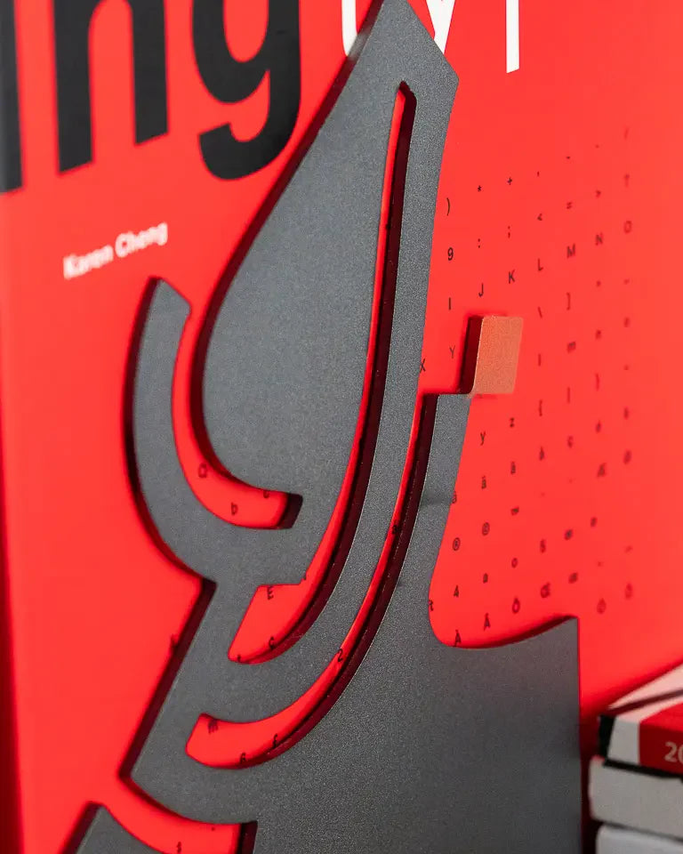 Eternal Bookends by Wissam Shawkat — precision-cut steel bookends with Arabic calligraphy in matte black and red